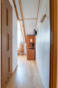 an attic hallway with a wooden floor and a door at Piast in Karwia