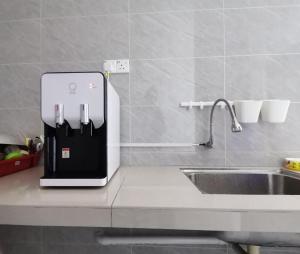 a refrigerator on a kitchen counter next to a sink at Jiaxin Dormitory-Setia Indah 家馨青年旅宿 in Johor Bahru
