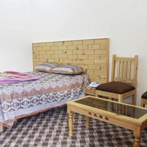 ein Schlafzimmer mit einem Bett, einem Stuhl und einem Tisch in der Unterkunft Ghizer Inn Hotel And Resturant in Gākuch