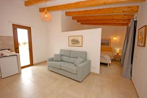 a living room with a chair and a bedroom at Agroturisme Rafal Nou in Manacor