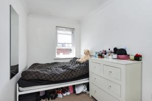 um pequeno quarto com uma cama e uma cómoda em Reading Central Apartment em Reading