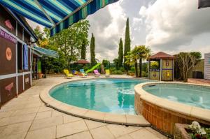 a swimming pool with a patio and a playground at Le tiki beach in Buchères