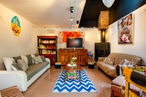 a living room with a couch and a tv at Le tiki beach in Buchères