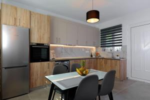 a kitchen with a table and chairs and a refrigerator at Michaela's Apartment in Koskinou