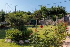 a garden with roses and a goal at Michaela's Apartment in Koskinou