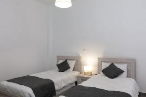 two beds sitting next to each other in a room at Michaela's Apartment in Koskinou