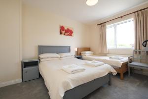 1 dormitorio con 2 camas y ventana en Four Seasons B&B en Galway