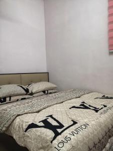 1 Schlafzimmer mit 2 Betten und schwarzen und weißen Decken in der Unterkunft Riqayraa Muslim Homestay in Seremban