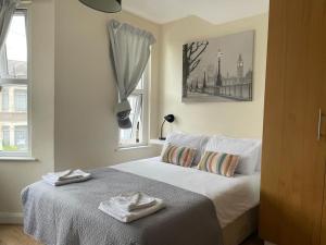 a bedroom with a bed with two towels on it at Amazing Studio Room in Ilford! in Ilford