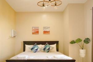 a bedroom with a bed and a chandelier at CityCenter Queen-Bed Room w Panoramic Skyline View in Naga
