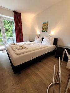 a large bed in a hotel room with a large window at Winterberg Appartement 21085 in Winterberg