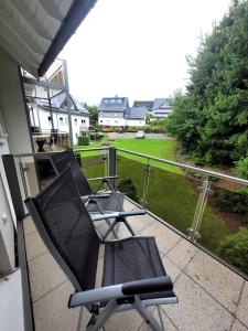 two chairs on a balcony with a view of a yard at Winterberg Appartement 21085 in Winterberg