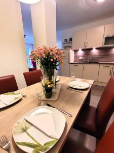 Una mesa de comedor con un jarrón de flores encima. en Winterberg Appartement 21085, en Winterberg