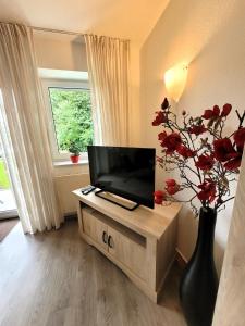 a living room with a television and a vase with flowers at Winterberg Appartement 21085 in Winterberg