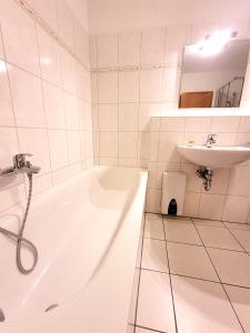 Un baño blanco con bañera y lavabo. en Winterberg Appartement 21085, en Winterberg 16 fotos más