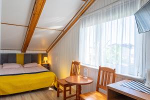a bedroom with a bed and a table and a window at Piast in Karwia