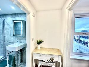 een badkamer met een wastafel, een spiegel en een raam bij Modern & Brand New Apartment in Whitstable Centre in Whitstable