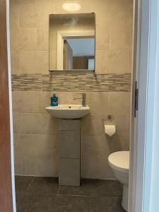 a bathroom with a sink and a toilet and a mirror at Amazing Studio Room in Ilford! in Ilford