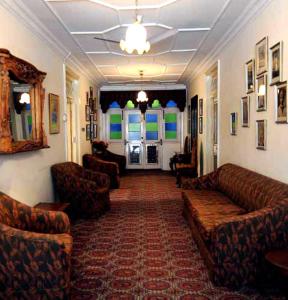 a living room with couches and chairs in a room at WelcomHeritage Taragarh Palace in Kangra