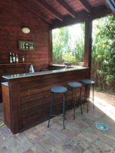 an outdoor kitchen with stools at a bar at Villa at Tuscany border, swimming pool, golfcourse in Tarquinia