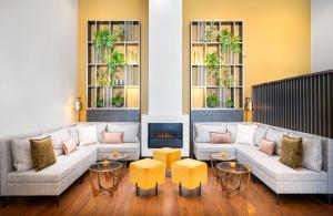 a living room with couches and a fire place at Leonardo Hotel Salzburg Airport in Salzburg