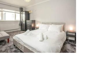 um quarto com uma grande cama branca com duas velas em Broadshade Holiday Apartments em Paignton