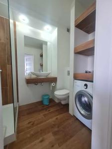 a bathroom with a sink and a washing machine at Apartament Sunrise Poznań - Self Check-in 24h in Poznań