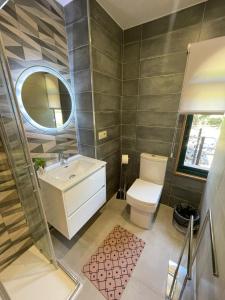 y baño con lavabo, aseo y espejo. en Casa y Apartamento Rural Terra Celta en Salceda de Caselas, en Salceda