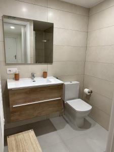 a bathroom with a toilet and a sink and a mirror at Apartamentos Encanto Mudéjar in Teruel +16 photos