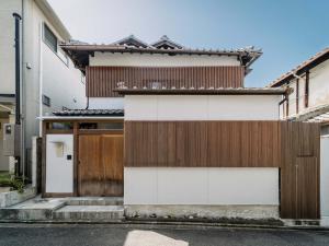 a house with a brown and white facade at Yuzunoe Machiya House in Kyoto