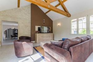 ein Wohnzimmer mit einem Sofa und einem TV in der Unterkunft Au phil de lo in Dolancourt
