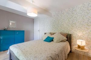 een slaapkamer met een bed en een blauwe kast bij Au phil de lo in Dolancourt