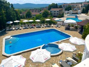 Draufsicht auf ein Schwimmbecken mit Sonnenschirmen in der Unterkunft Hotel Gamartata in Duni