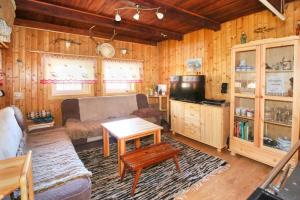 a living room with a couch and a table and a tv at Chata nad jazerom. in Sklené Teplice