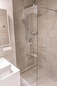 a shower with a glass door in a bathroom at Top 9 Alpe Maritima - Lakeview Apartment mit Bergkulisse in Annenheim