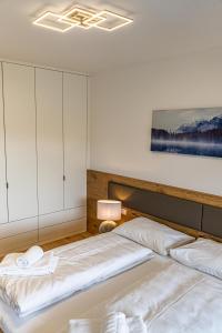 a bedroom with two beds and a painting on the wall at Top 9 Alpe Maritima - Lakeview Apartment mit Bergkulisse in Annenheim