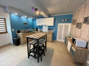 a kitchen with a table and some blue walls at La belle vue in Accolay