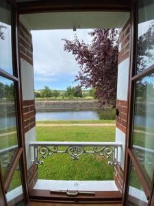 an open window with a view of a body of water at La belle vue in Accolay