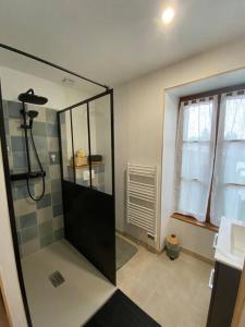 La salle de bains est pourvue d'une douche avec une porte en verre. dans l'établissement La belle vue, à Accolay