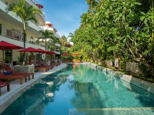 uma piscina num resort com cadeiras e árvores em Anantara Vacation Club Legian em Legian