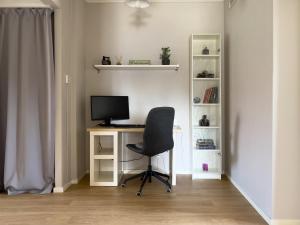 a desk with a computer and a chair in a room at Långträsk Apartments Villa in Långträsk