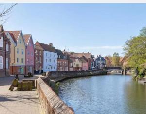 a river in a town with buildings and houses at Luxury 5 Bed house in the City, includes parking & EV point in Norwich