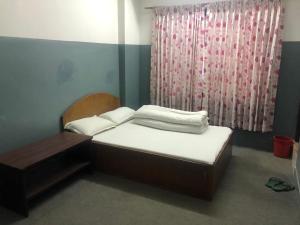 una piccola camera da letto con un letto e una finestra di HOTEL TRILOK a Kathmandu