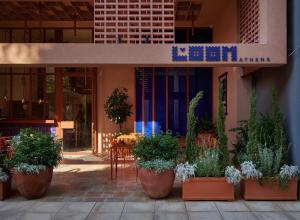 a group of potted plants in front of a restaurant at LOOM ATHENS in Athens