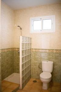 een badkamer met een toilet en een douche en een raam bij Vacation rental Fuengirola in Fuengirola