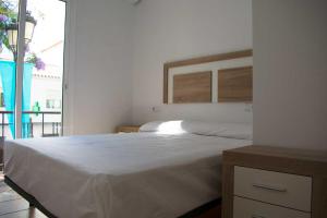 een slaapkamer met een groot wit bed en een raam bij Vacation rental Fuengirola in Fuengirola