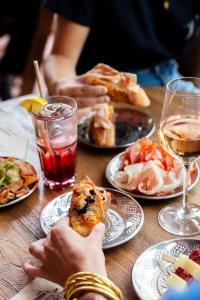 uma mesa com pratos de comida e copos de vinho em Hôtel Lilybloom em Le Havre