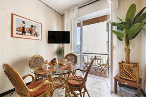 a dining room with a table and chairs and a balcony at Riva Mare 2 in Vado Ligure