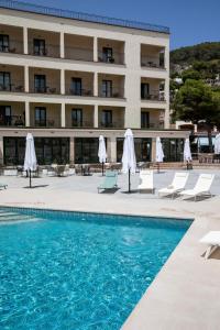 un hôtel avec une piscine, des chaises et un bâtiment dans l'établissement EVENIA CORAL BOUTIQUE, à L'Estartit