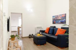 バーリにあるModern Stone Apartment in the Heart of Bariのリビングルーム(青いソファ、オレンジの枕付)
